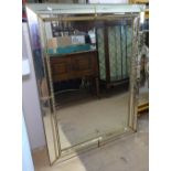 A gilt-metal cushion-framed rectangular wall mirror, W90cm