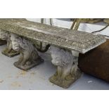 A weathered rectangular concrete garden bench on lion supports, W112cm