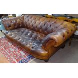 A modern studded brown leather upholstered 3-seater Chesterfield settee, with rollover arm, on