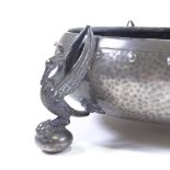An Arts and Crafts planished pewter fruit bowl, on cast phoenix design feet, stamped Homeland,