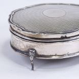 A George V silver dressing table jewel box, oval scalloped form with engine turned decoration on