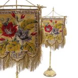 A pair of 19th century Berlin beadwork face screens, mounted on original gilt-brass stands on relief