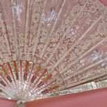 A hand painted lace fan, with carved mother of pearl and ivory sticks, in frame, frame width 76cm.