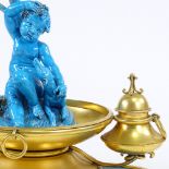 An ornate 19th century French gilt-metal desk stand, surmounted by a blue glazed ceramic cherub