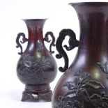 A pair of Japanese 19th century patinated bronze vases, with relief moulded prunus decoration, on