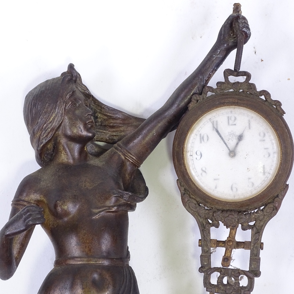 A 19th century French patinated spelter Mystery clock, supported by a Classical figure