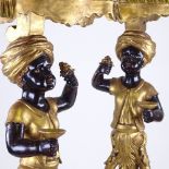 A pair of ornate carved painted and gilded wood, Blackamoor figure pedestals on carved giltwood