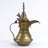 A Middle Eastern engraved brass ewer, height 28cm