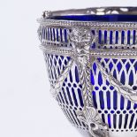 A George V silver swing-handled sugar basket, pierced Adams style decoration with floral swags,