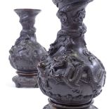 A pair of heavy relief moulded patinated bronze baluster vases, with dragon and crab designs, on