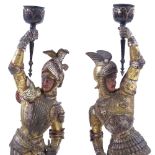 A pair of Victorian painted and gilded spelter candle holders, supported by knights in armour,