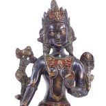 An Indian patinated bronze seated deity, with traces of painted decoration, height 21cm