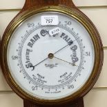 A carved oak-cased aneroid barometer and thermometer, by Brevingtons of London, with ceramic