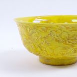 A Chinese yellow glazed bowl with embossed dragon decoration, and 6 character mark, 15.5cm diameter