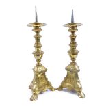 A pair of cast-brass pricket candlesticks, relief embossed religious portraits and scenes, overall