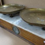 An Antique set of scales, stamped brass plates with white marble top and oak case, case length 57cm