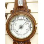 A carved oak-cased aneroid wall barometer, with ceramic dials, height 88cm