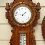 A Victorian carved oak-cased aneroid wall barometer, with inset clock, ceramic dials and carved