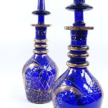 A pair of 19th century gilded Bristol blue glass decanters, with conical stoppers, overall height