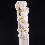A 19th century ivory page turner, with finely carved cherub and floral decorated handle, length 30cm
