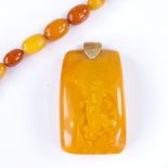 A graduated string of butterscotch amber beads, and a barrel-shaped amber? pendant, largest bead