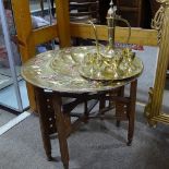 An Islamic copper and brass tray on folding stand, diameter 60cm, and an Islamic brass ewer and