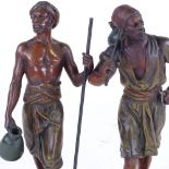 A pair of bronze patinated spelter figures of African men, height 31cm