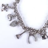 A late 20th century silver curb link charm bracelet, with various silver charms and heart padlock