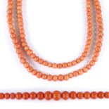 A long Antique graduated polished coral bead necklace, and a smaller example with unmarked yellow