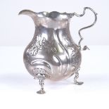 An 18th century Danish silver baluster cream jug, relief embossed and engraved floral decoration,