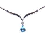 A modern 9ct white gold blue topaz and diamond pendant necklace, on 9ct white gold herringbone