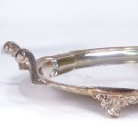 A George V oval silver 2-handled tea tray, shaped rim with raised handles and foliate feet, by