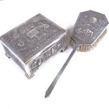 An early 20th century Indian sterling silver cigarette box and matching hand brush, relief