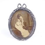 An Art Nouveau Danish oval silver-fronted photo frame, bow decoration with stand, hanging loop and
