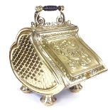 A Victorian embossed brass coal bin, with floral relief decorated hinged lid and shovel