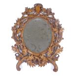 A 19th century Black Forest carved wood-framed oval wall mirror, in holly decorated surround, height