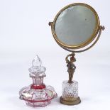 A gilt-bronze and cut-glass shaving mirror, with Classical cherub support, and a cranberry overlay