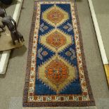 A hand woven Persian red and blue ground wool rug