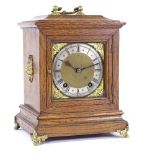 A German oak-cased 8-day bracket clock, brass dial with Roman numeral hour markers and brass lion