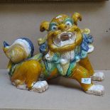 A large Chinese treacle glaze terracotta Dog of Fo, length 40cm