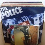 A box of LPs and 45rpm records, including The Police, The Beatles, and Bob Marley