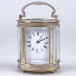 A small oval silver plated carriage clock, white enamel dial with Roman numeral hour markers and