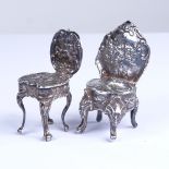 2 miniature silver doll's house chairs, allover relief embossed foliate decoration, with lion paw