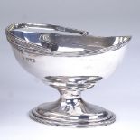 An Edwardian oval silver swing-handled pedestal sugar bowl, reeded edge decoration, by Daniel and