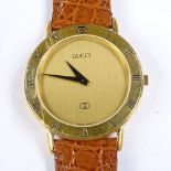 GUCCI - a gold plated stainless steel quartz wristwatch, gilt dial with Roman numeral hour marker