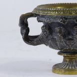 A small 19th century patinated bronze Classical urn, the frieze decorated with masks, rim diameter