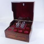 A large brass-bound mahogany campaign decanter box, containing 4 original square cut-glass