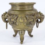 A Chinese polished bronze jardiniere, with relief cast dragon frieze, on 3 elephant feet, rim