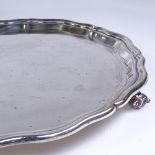 An Edward VIII circular silver salver, scalloped rim with 3 scrolled acanthus leaf feet, by Viner'