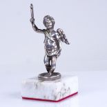 An unmarked cast-silver cherub figure, on modern white marble base, overall height 10cm Good overall